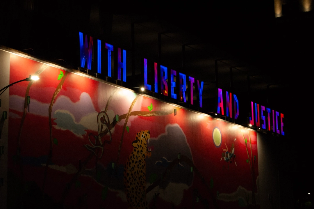 A mural under big letters that read "WITH LIBERTY AND JUSTICE."