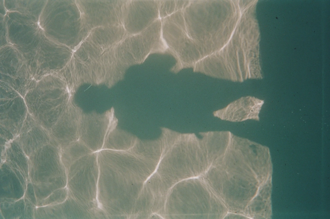 A person's shadow on a pool floor.