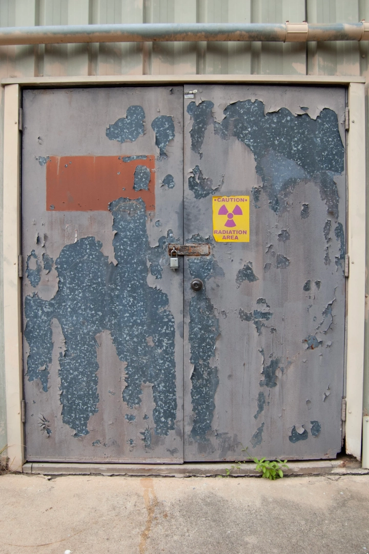 An old door with a sign that reads: "CAUTION RADIATION AREA."