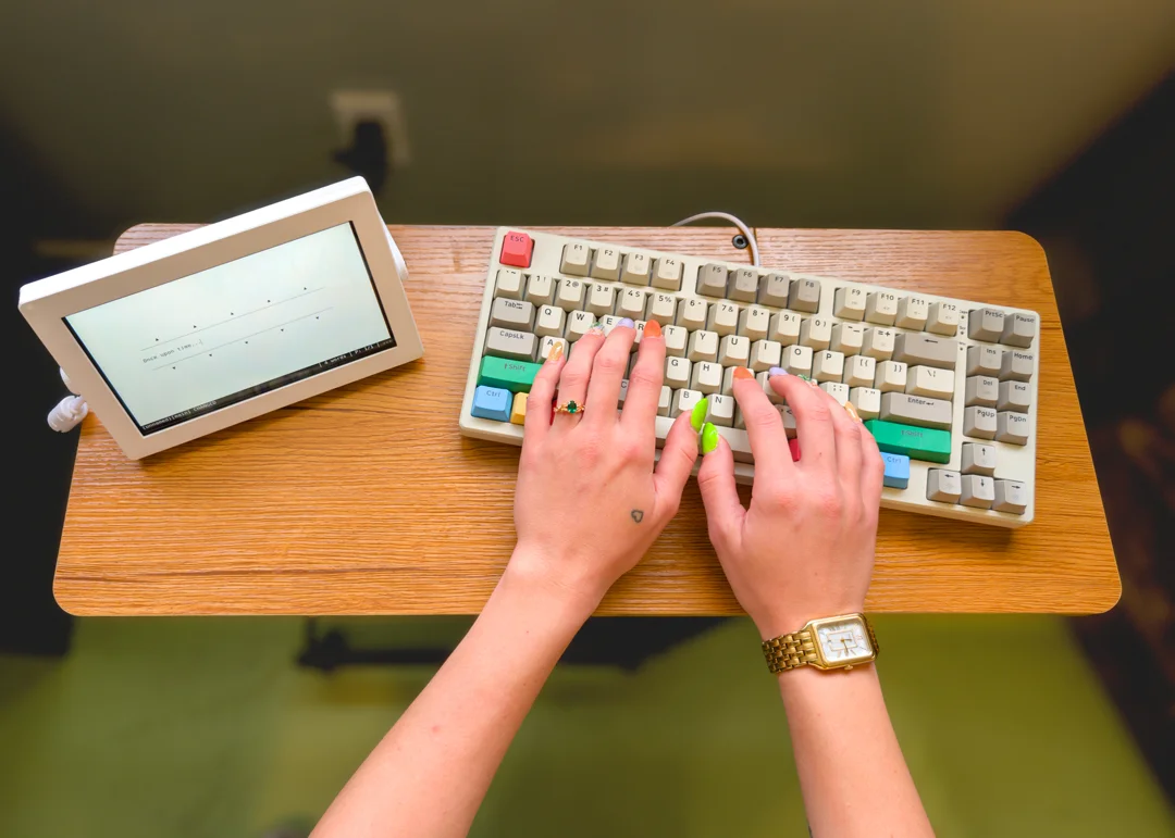 A person typing on the typewriter keyboard.